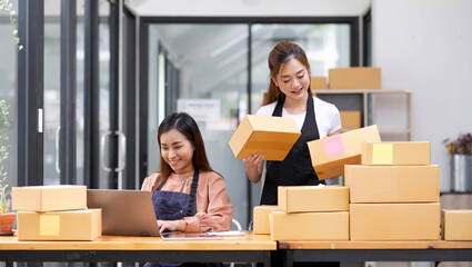 Two Asian woman owned business startup sme small business entrepreneur SME distribution warehouse with parcel mail box. SME owner in office. Online marketing and product packaging and delivery service