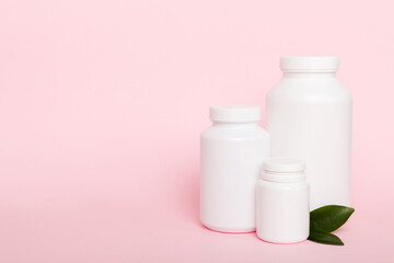 supplement pills with medicine bottle health care and medical top view. Vitamin tablets. Top view mockup bottle for pills and vitamins with green leaves, natural organic bio supplement, copy space