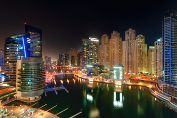 Night view of Dubai Marina skyscrapers in Dubai, UAE. Dubai Marina is a canal city carved along a  3 km stretch of Persian Gulf shoreline and is the heart of what has become known as "new Dubai"