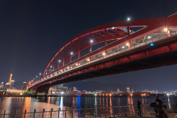 Fototapeta na wymiar This red bridge connects the city of Kobe with Kobe airport.At night this bridge is lit up with lights. 