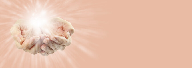 Distant healing message banner background - female cupped hands with a light burst radiating out on...