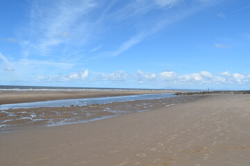 Dramatic cloudy sky over the sea with waves crashing onto the beach. Taken in Fleetwood Lancashire England. 