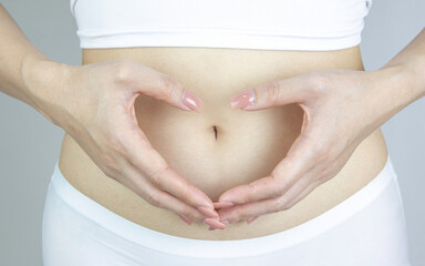 Woman hand rubs stomach with symbol of protection for health care. Concept of good digestion,...