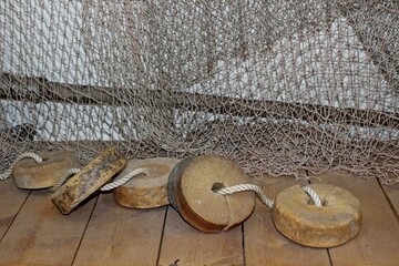 fishing nets with wooden floats on a wooden floor