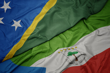 waving colorful flag of equatorial guinea and national flag of Solomon Islands .