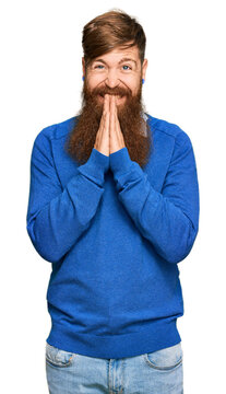 Young irish redhead man wearing casual clothes praying with hands together asking for forgiveness smiling confident.