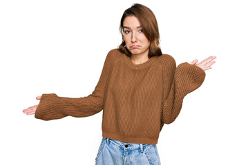 Young caucasian girl wearing casual clothes clueless and confused expression with arms and hands...