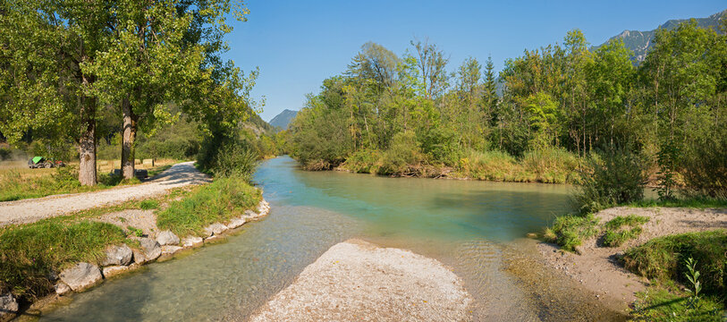 Loisach river with riverside walkway and green trees beside, upper bavaria