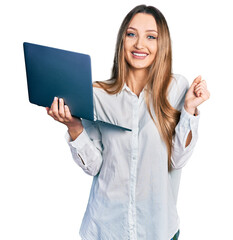 Beautiful caucasian woman working using computer laptop screaming proud, celebrating victory and...
