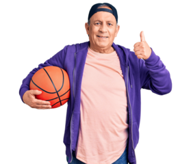 Senior handsome grey-haired man holding basketball ball smiling happy and positive, thumb up doing excellent and approval sign