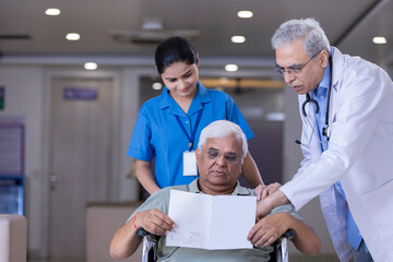Obraz premium Nurse with doctor explaining treatment to disabled patient in wheelchair at hospital 