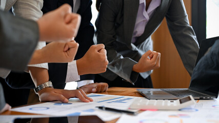Businesspeople celebrating at the meeting room. winning, achievement hand gesture.