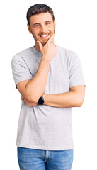 Fototapeta premium Handsome young man with bear wearing casual tshirt looking confident at the camera smiling with crossed arms and hand raised on chin. thinking positive.