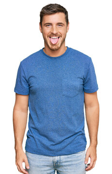 Handsome caucasian man wearing casual clothes sticking tongue out happy with funny expression. emotion concept.