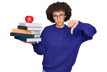 Young hispanic girl wearing glasses holding books and red apple with angry face, negative sign showing dislike with thumbs down, rejection concept