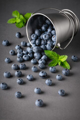 Fresh blueberries in small bucket on the gray table