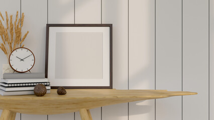 Empty image poster frame mockup on a wooden table with decor over the white plank wall.