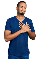 Young african american man wearing casual t shirt smiling with hands on chest with closed eyes and grateful gesture on face. health concept.