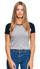 Obraz premium Young blonde woman wearing casual clothes relaxed with serious expression on face. simple and natural looking at the camera.
