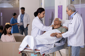Doctors checking heartbeat of patient using stethoscope lying on hospital bed
