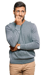 Handsome hispanic man wearing casual clothes looking stressed and nervous with hands on mouth...