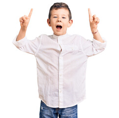 Cute blond kid wearing elegant shirt smiling amazed and surprised and pointing up with fingers and...