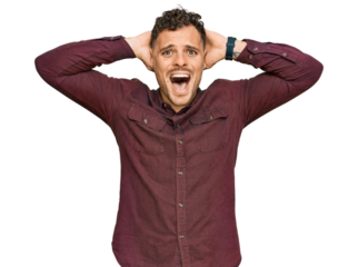 Young hispanic man wearing casual clothes crazy and scared with hands on head, afraid and surprised of shock with open mouth