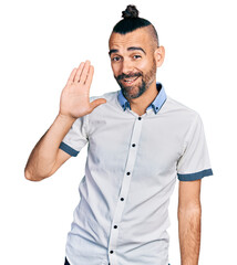 Hispanic man with ponytail wearing casual white shirt waiving saying hello happy and smiling, friendly welcome gesture © Krakenimages.com