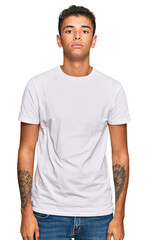 Young handsome african american man wearing casual white tshirt relaxed with serious expression on face. simple and natural looking at the camera.