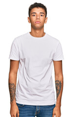Obraz premium Young handsome african american man wearing casual white tshirt relaxed with serious expression on face. simple and natural looking at the camera.