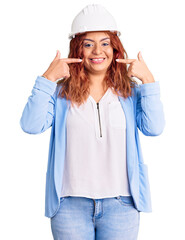 Young latin woman wearing architect hardhat smiling cheerful showing and pointing with fingers teeth and mouth. dental health concept.