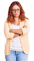 Young latin woman wearing business clothes skeptic and nervous, disapproving expression on face with crossed arms. negative person.