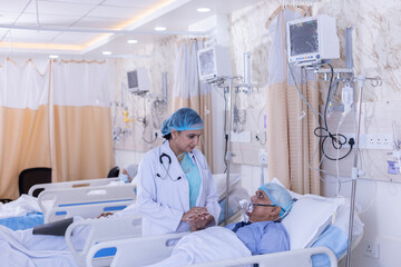 Doctor holding hands of senior patient in oxygen mask in hospital
