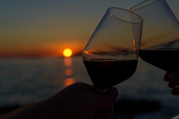 two glasses of wine with a sunset 
