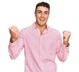 Fototapeta premium Hispanic young man wearing casual clothes screaming proud, celebrating victory and success very excited with raised arms