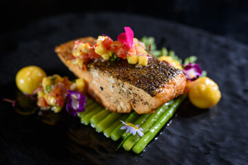 Fried salmon steak with potatoes and vegetables on wooden table