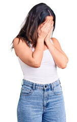 Young beautiful brunette woman wearing casual sleeveless t-shirt with sad expression covering face with hands while crying. depression concept.