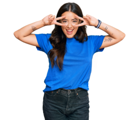 Beautiful brunette young woman wearing casual clothes doing peace symbol with fingers over face, smiling cheerful showing victory