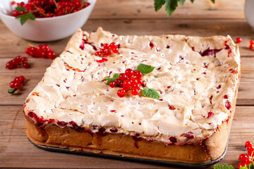 Homemade cottage cheese casserole garnished with redcurrant on wooden table