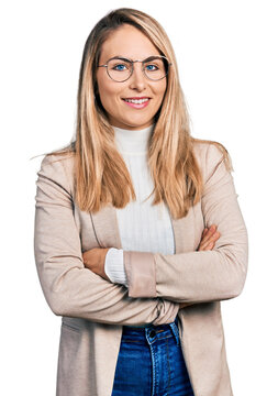 Young blonde woman wearing business shirt and glasses happy face smiling with crossed arms looking at the camera. positive person.