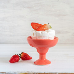 Ricotta cheese in ceramic vase for Jewish holiday Shavuot on white wooden background.