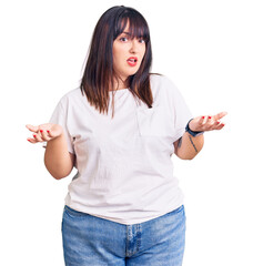 Young plus size woman wearing casual clothes clueless and confused with open arms, no idea concept.