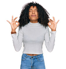 Young african american girl wearing casual clothes relaxed and smiling with eyes closed doing meditation gesture with fingers. yoga concept.