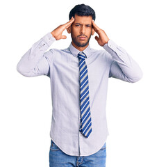 Young latin man wearing business clothes suffering from headache desperate and stressed because pain and migraine. hands on head.