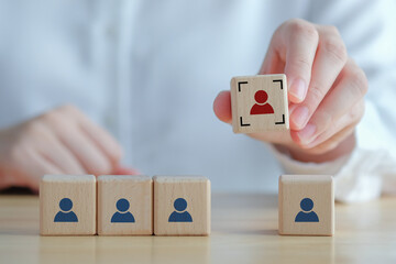 Business hiring and recruitment selection. Career opportunity. Human Resource Management. finding human. Hand choosing focus red human icon on wooden block. Choice of employee leader from the crowd.