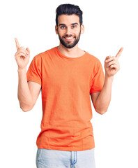 Young handsome man with beard wearing casual t-shirt smiling confident pointing with fingers to different directions. copy space for advertisement