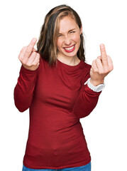 Young blonde woman wearing casual clothes showing middle finger doing fuck you bad expression, provocation and rude attitude. screaming excited