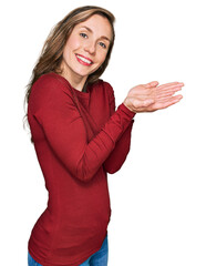 Young blonde woman wearing casual clothes pointing aside with hands open palms showing copy space, presenting advertisement smiling excited happy