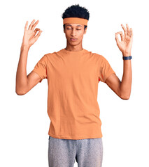 Young african american man wearing sportswear relax and smiling with eyes closed doing meditation gesture with fingers. yoga concept.