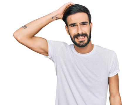 Young hispanic man wearing casual white t shirt confuse and wonder about question. uncertain with doubt, thinking with hand on head. pensive concept.